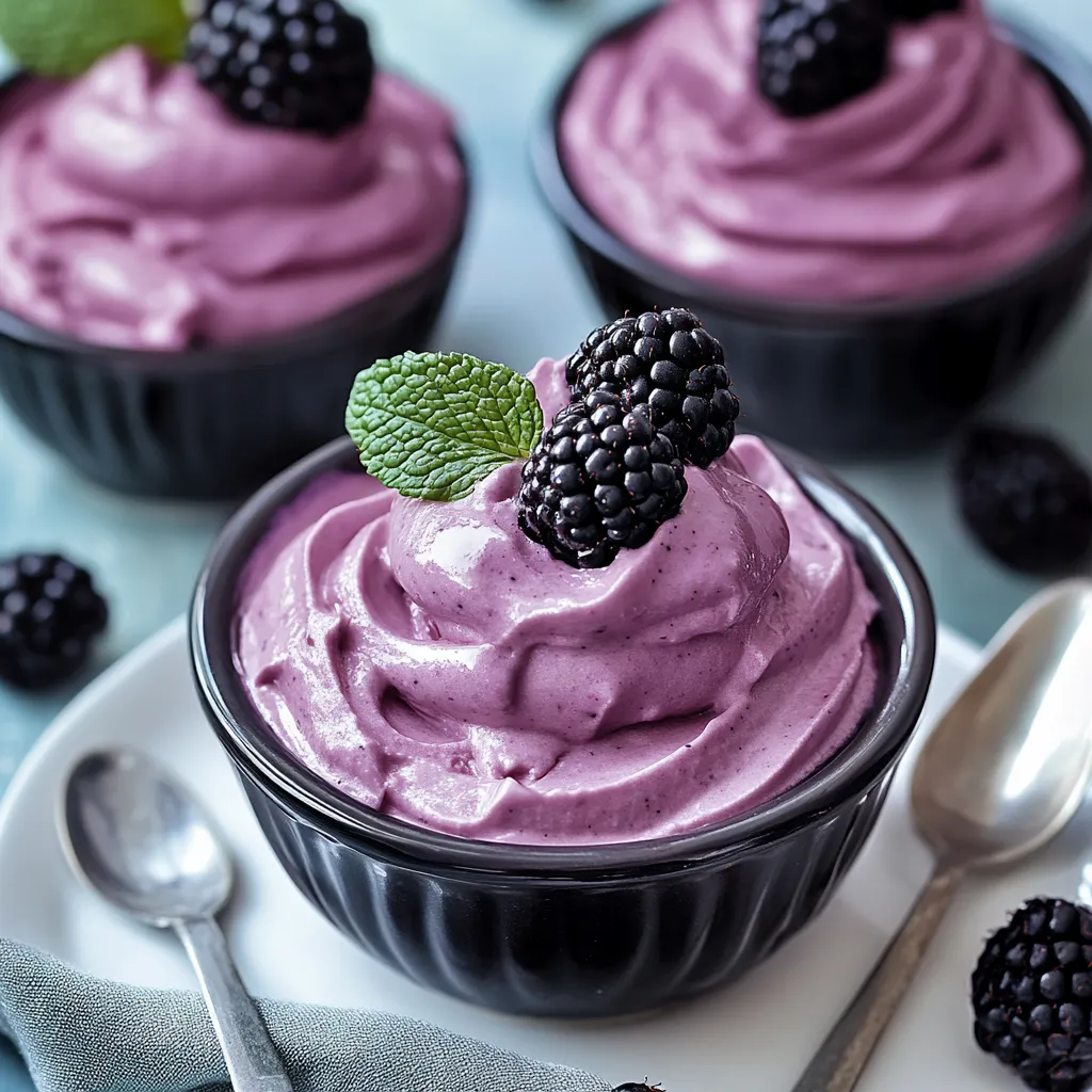 A cup of blackberry yogurt with a spoon.