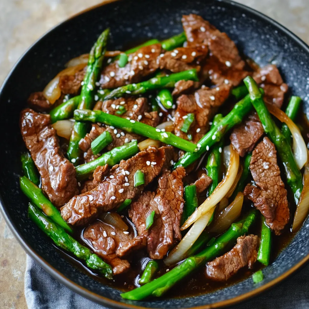 A bowl of beef and asparagus.