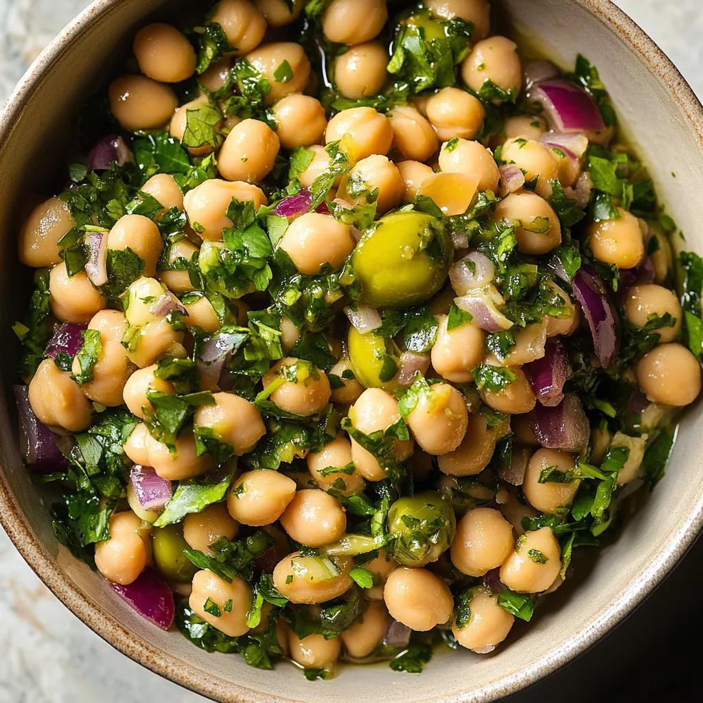 A bowl of beans with green toppings.
