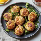 A plate of meatballs with greens.